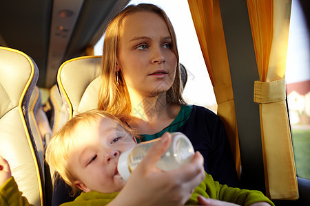 母亲和孩子在公共汽车上游客高清图片素材