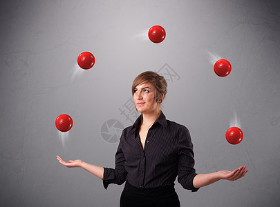 年轻女孩站立和玩弄红色球平衡游戏运动戏法享受管理人员风险手势控制戏法者图片