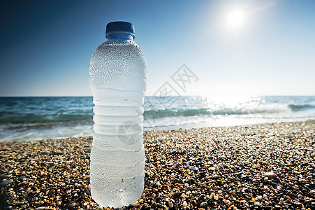 海边的沙滩上有一瓶淡水阳光饮料塑料食物海滩天空边缘生活城市风景图片