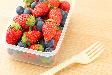 塑料容器中的草莓和蓝莓混合工作叶子木头生活方式食品盒子食物桌子时间水果图片