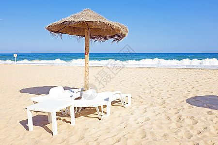 拉各斯波图附近海滩上挂着的雨伞和沙椅图片