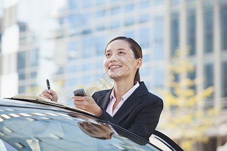 利用电话和笔记的汽车女商务人士地位协会图片