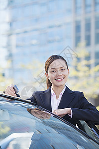 女商务人士站在汽车旁 看镜头公司图片
