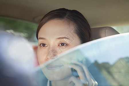 透过汽车窗口浏览电话上女商务人士的车窗高清图片