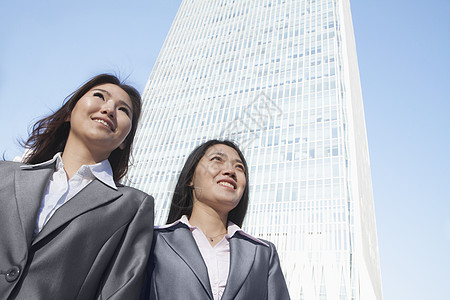 站在北京中国世贸中心前的两位女商务人士图片