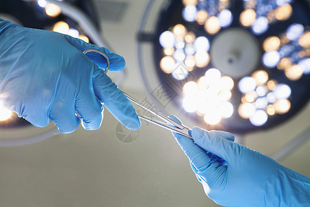 戴手套的手通过手术剪刀 手术室 医院的特写镜头两个人外科团结器材人体工作服保健合作医护人员专注图片
