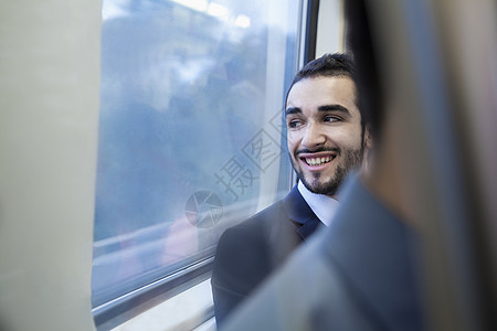 年轻的商务人士笑着看着地铁窗外的年轻商务人士图片