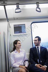 两个坐在地铁上聊天的青年商业人士 两人在地铁坐着图片