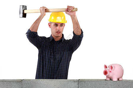 一个建筑工人 即将开一家装着大锤的小猪银行图片