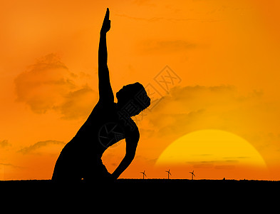 在日落下做瑜伽的妇女的休眠图片