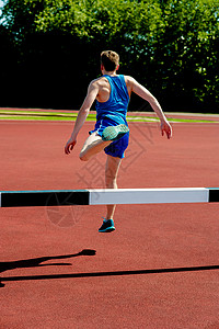 运动员在障碍上跳跃课程游戏路线马场赛跑者竞技场场地男人比赛体育场图片