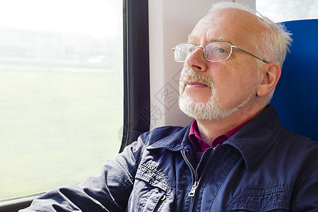 坐在马车窗户旁边的放松的老人家车皮运输长椅蓝色火车乘用车男性教练旅行阴影背景图片