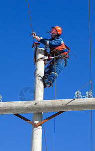 电平柱顶上工作的电动器男人技术工具工人工作服电压登山者人手建设者蓝色图片