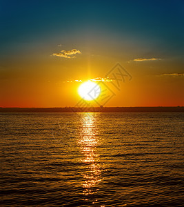 黑暗的河边日落地平线旅行天空橙子蓝色海浪天气太阳晴天海岸图片