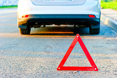 红色警示三角形和一辆汽车停在路边图片