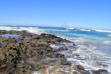 带白泡沫的动荡海洋波浪击打沿海石块 Fuert蓝色海滩侵蚀悬崖海浪晴天碎石海岸岩石崎岖图片