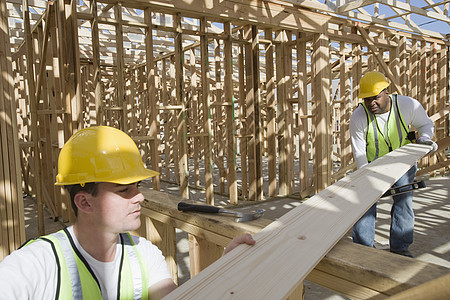 在建筑工地共同工作的体力工人 工作测量平衡专注安全帽工具合作建筑工人建设者男子技术图片