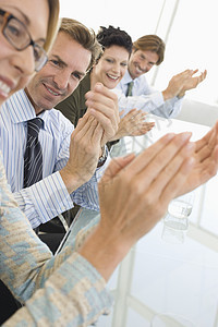 与同事在会议室鼓掌欢呼的欢乐生意人图片