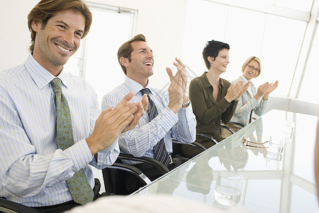 愉快的商务同事们在会议室鼓掌欢呼图片