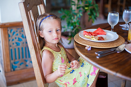 可爱的小女孩在度假餐厅吃早饭 很可爱闲暇假期酒店果汁婴儿女孩时间孩子酒吧羊角图片