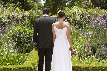 新婚夫妇在花园散步的近视图片