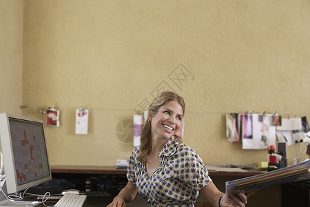 德国杜宾犬桌面微笑的年轻女性在办公室上交文件背景