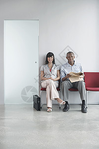一名青年男女坐在办公室走廊的椅子上的长长肖像画全长图片
