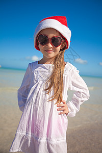 在奇异海滩上 戴着红帽子的小女孩圣天窗和墨镜微笑头发女孩帽子婴儿喜悦热带童年季节海岸图片