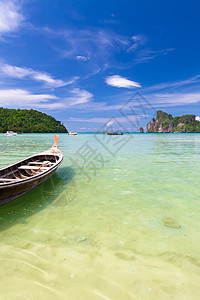 热带海滩上的木船海岸风景水晶游客海洋假期树叶运输旅游情调图片