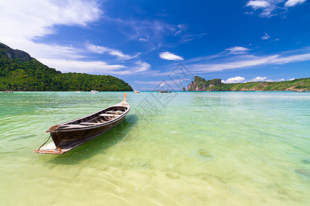 热带海滩上的木船天空异国海景树叶情调运输海洋天堂海岸假期图片