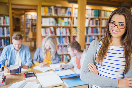 图书馆背景图书馆中与有背景的其他人一起学习的女学生学校双臂写作教科书眼镜教育书柜读者女士笔记本背景
