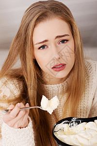 悲伤 担心的美丽的女人 吃冰淇淋满的高清图片素材