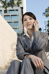 使用手机笑亚洲商业妇女 坐在楼梯上a网络技术喜悦人士快乐电子邮件微笑电话女士商务图片