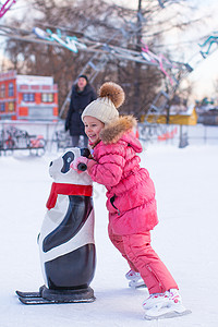 可爱的小女孩在冰场滑冰溜冰场孩子数字学习女孩套装企鹅手套运动幸福图片