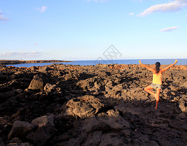 在日出海边练瑜伽的妇女图片
