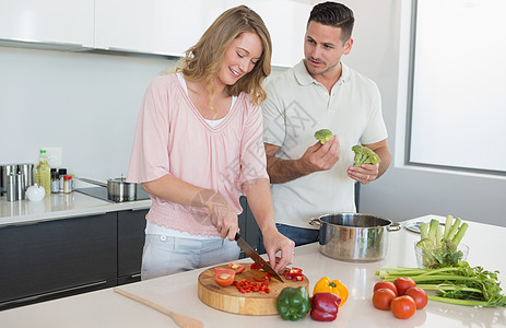 一对夫妇在厨房做饭健康饮食素食者女性菜板男性辣椒台面饮食女士便服背景图片