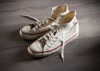 白色画布运动鞋橡皮帆布鞋木地板服装青年文化概念尘土蕾丝桌子图片