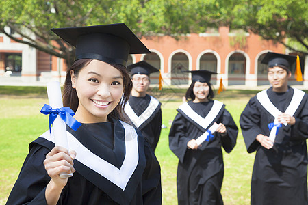 微笑着的大学毕业生展示文凭图片