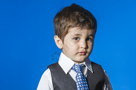 头儿 蓝色背景的可爱小男孩肖像孩子领带乐趣微笑办公室教育套装职业青年男性图片