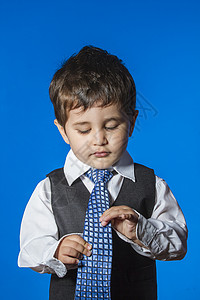 头儿 蓝色背景的可爱小男孩肖像衣服职业套装微笑白色孩子电话青年儿子童年图片