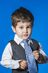 头儿 蓝色背景的可爱小男孩肖像眼镜微笑电话套装领带人士领导白色童年男生图片