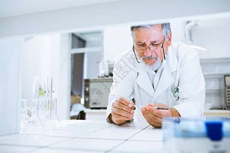 在实验室进行科学研究的高级男性研究员医生实验外套化学品生物学科学家医院烧杯测试药品图片
