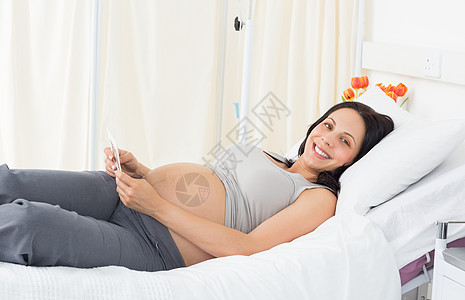 躺在床上的幸福孕妇孕产孕妇装医疗保健怀孕生长报告枕头肚子女士背景图片