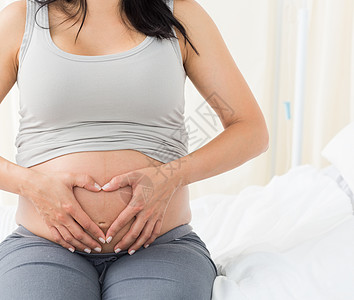 孕妇在肚子上做心脏形状的孕妇分娩女士诊所医院保健孕妇装孕产卫生腹部怀孕背景图片