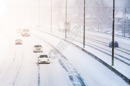 公路上的日落光和暴雪扰乱交通阳光降雪旅行城市季节车辆路线日落状况图片