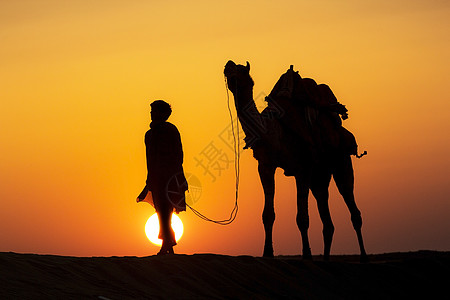 荒漠的当地人走着骆驼穿过Thar沙漠冒险踪迹日出沙丘日落沙漠阴影橙子文化场景图片