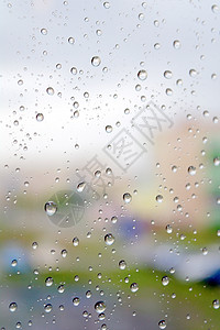 超慢运动中的雨滴秋天下雨 窗子上下水滴驾驶灰色绿色建筑物薄雾蓝色时间玻璃天气天空背景