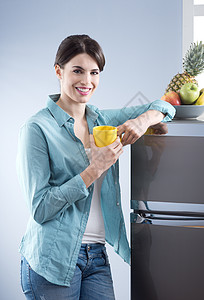 家用冰箱厨房里有迷人的女人倾斜家用电器微笑冰箱幸福女性快乐魅力女士果盘背景