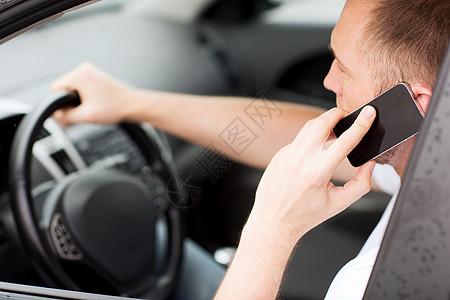 驾驶汽车时使用电话的人工作男性司机城市注意力事故运输车辆交通危险图片