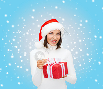 带着礼物盒的圣塔帮手帽子中的微笑着女人礼物庆典快乐假期毛衣幸福雪花羊毛展示套衫图片